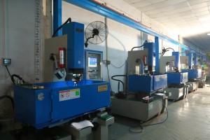 Rows of blue CNC machines on the factory floor