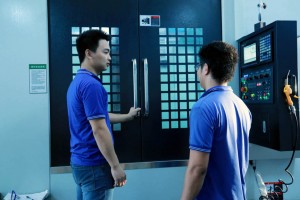 Technicians checking a CNC machine control panel